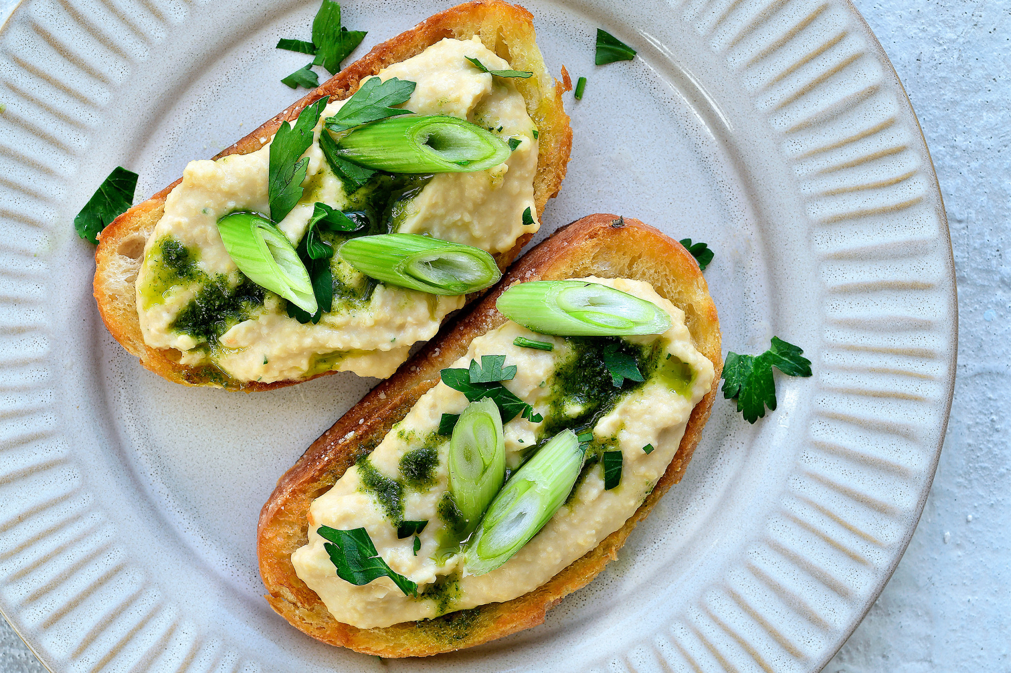 Toast met spread van witte bonen, tahini en peterselie-olie